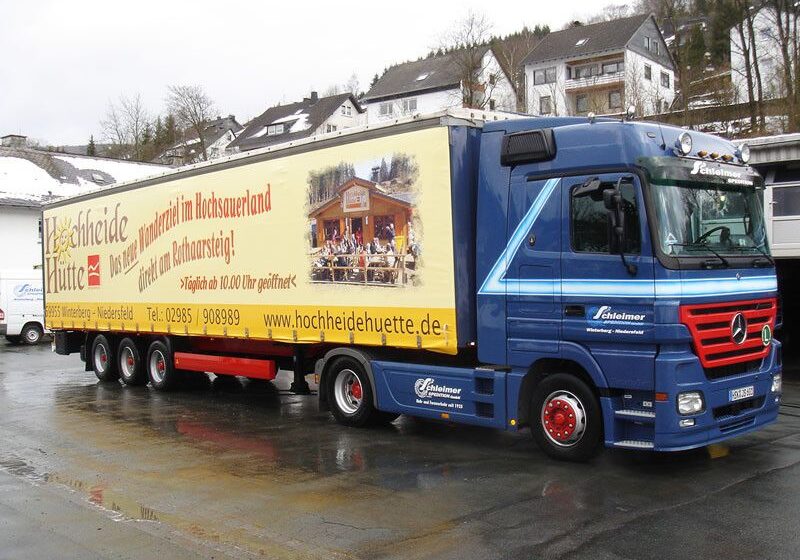 Mercedes-Benz Lkw mit gelber Werbung für Hochheide Hütte auf der Seite des Fahrzeugs.